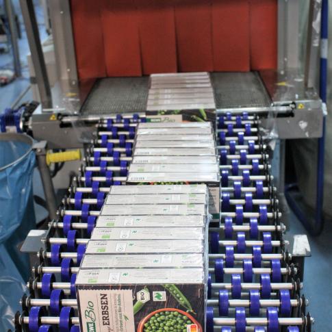 Les paquets de boîtes de légumes surgélés sortent du tunnel de rétraction