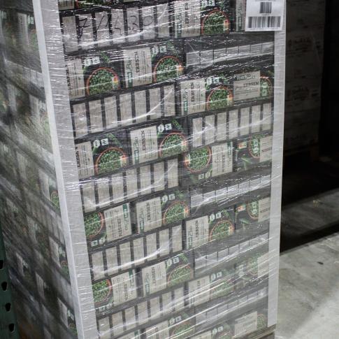 Palette pleine de cartons de légumes surgelés regroupés sous film rétractable